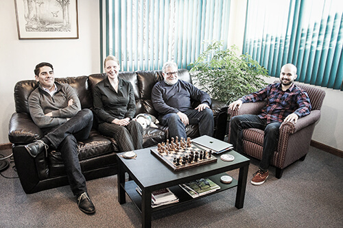 A group of Drupal developers sitting on a couch in an office.